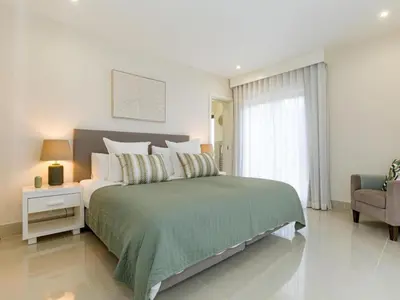 a bedroom with a large bed and a chair at Apartment Pine Hills Reva Santuary Modern Elegance by Interhome in Vilamoura