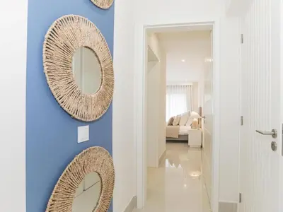 a hallway with two mirrors on a blue wall at Apartment Pine Hills Reva Santuary Modern Elegance by Interhome in Vilamoura