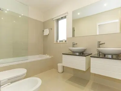 a bathroom with two sinks and a toilet and a tub at Apartment Pine Hills Reva Santuary Modern Elegance by Interhome in Vilamoura