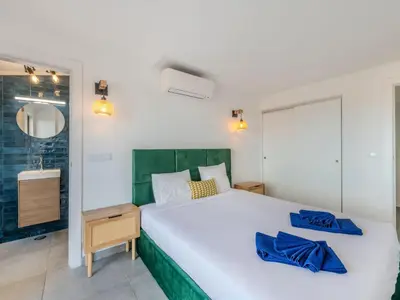 a bedroom with a large white bed with blue pillows at Apartment Villa Magna by Interhome in Albufeira