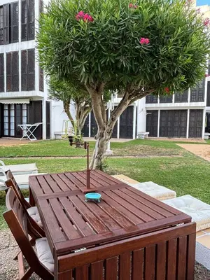 a wooden table and chairs in front of a tree at no22FM in Vilamoura