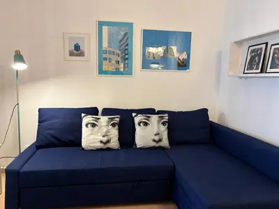 a blue couch with two faces on the pillows at no22FM in Vilamoura