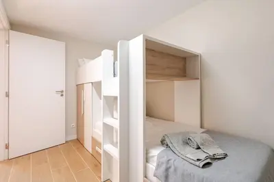 a small bedroom with a bed and open shelves at Casa Eden 2BR modern Apartment near Marina! Patio-Porch-WS-BBQ-FAST WIFI! in Quarteira