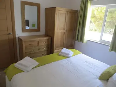 a bedroom with a bed with a dresser and a mirror at Luxury Villa with Private pool walking distance to beach and Marina in Quarteira