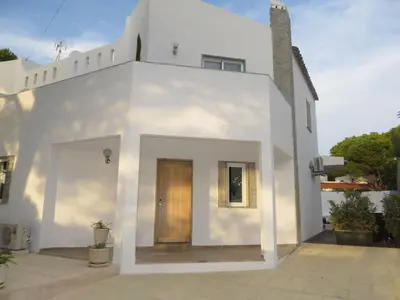 a white house with a door in front of it at Luxury Villa with Private pool walking distance to beach and Marina in Quarteira