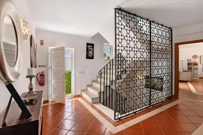 a bedroom with a bed and a chair at Al´Corais in Albufeira