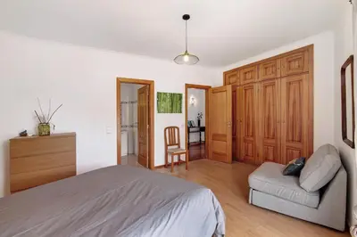 a bedroom with a bed and a chair and a mirror at Al´Corais in Albufeira