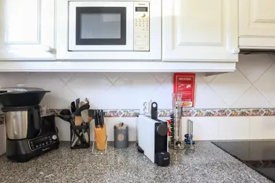 a kitchen counter top with a microwave and a counter sidx sidx at Jardins do Castelo - Piscina e tranquilidade - BY BEDZY in Albufeira