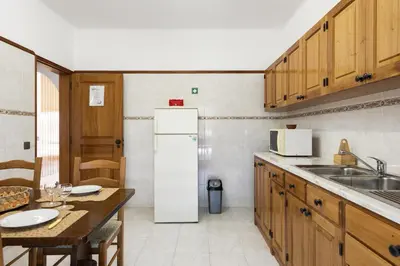 a kitchen with a white refrigerator and a table at Vila de santa Eulalia II - Albufeira in Albufeira