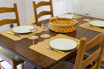 a wooden table with plates and wine glasses on it at Vila de santa Eulalia II - Albufeira in Albufeira