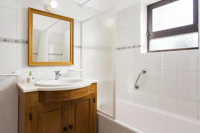 a bathroom with a sink and a tub and a mirror at Vila de santa Eulalia II - Albufeira in Albufeira