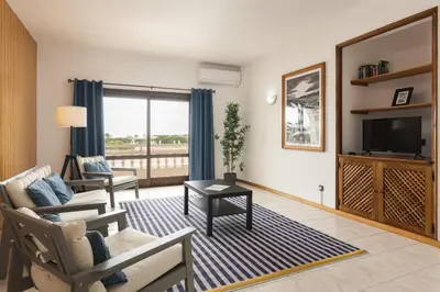 a living room with a couch and a tv at Vila de Santa EulAlia III - Albufeira in Albufeira