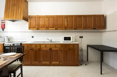 a kitchen with wooden cabinets and a microwave at Vila de Santa EulAlia III - Albufeira in Albufeira