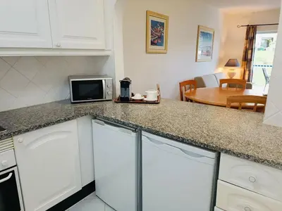 a kitchen with white cabinets and a sink at Balaia Golf Village T2 a 10 minutos da praia in Olhos de Água