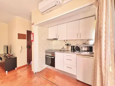 a kitchen with white cabinets and a stove top oven at Vilamoura Central 10 by Homing in Vilamoura