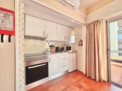 a kitchen with white cabinets and a stove top oven at Vilamoura Central 10 by Homing in Vilamoura