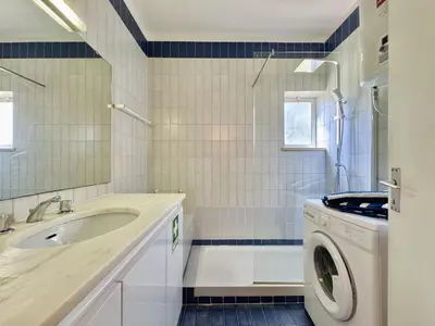 a bathroom with a sink and a washing machine at Vilamoura Central 10 by Homing in Vilamoura
