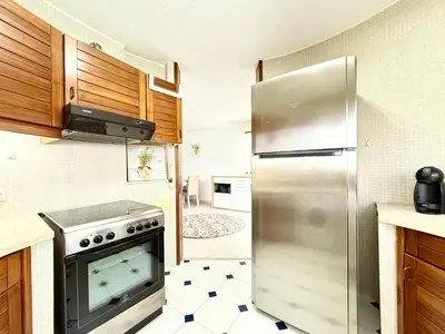 a kitchen with a stainless steel refrigerator and a tile floor at Home Out Albufeira - T1 Oura in Albufeira