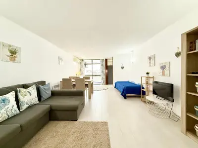 a living room with a couch and a television at Home Out Albufeira - T1 Oura in Albufeira
