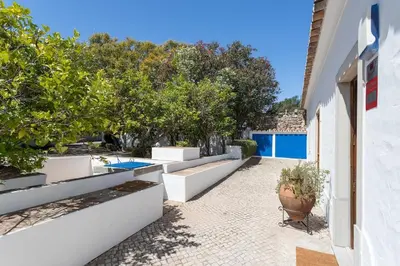 a courtyard with benches and trees in a house at True Local Village in Loulé