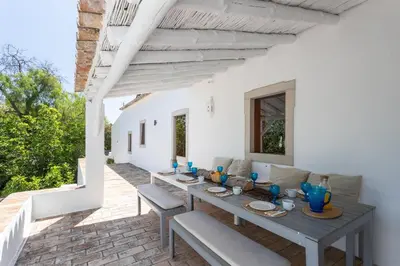 a patio with a wooden table and chairs at True Local Village in Loulé
