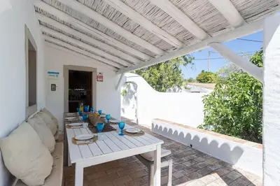 a white patio with a table and chairs at True Local Village in Loulé