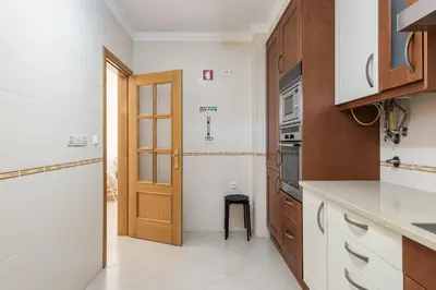 a kitchen with a wooden door and a counter top at Praia Village II - Peaceful condominium by HD in Vilamoura