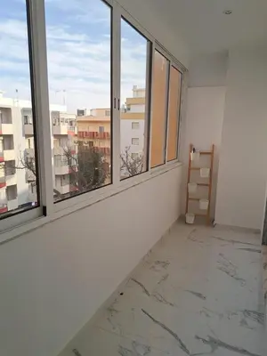 an empty room with windows and a marble floor at Apartamento T1 a 10m da praia Quarteira in Quarteira