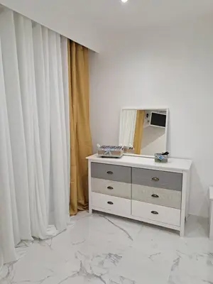a white dresser with a mirror in a room at Apartamento T1 a 10m da praia Quarteira in Quarteira
