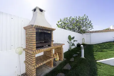 a brick fireplace in a yard next to a fence at Villa Menina by Ocvillas in Albufeira