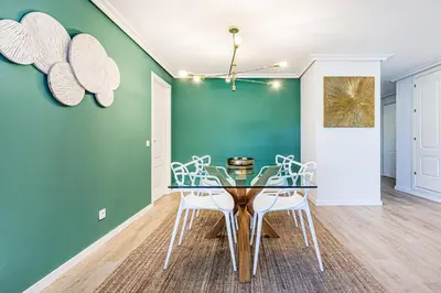a dining room with a glass table and white chairs at Apartamento T3 Praia da Falésia - PINE SUN PARK in Albufeira