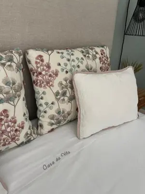 a bed with three pillows and a white pillow at casa da vila 33 in Faro