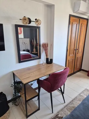 a dining room with a wooden table and a mirror at Albufeira Cozy Sea View with Balcony & Resort Access in Albufeira