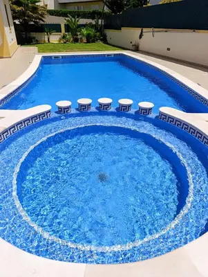 a large swimming pool with stools around it at Villa Ocean Gale in Albufeira