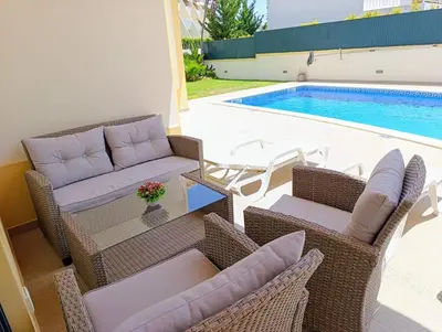 a patio with wicker chairs and a table next to a pool at Villa Ocean Gale in Albufeira