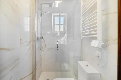a white bedroom with a white bed and a window at Ponta Grande Resort - Villa Maré in Albufeira