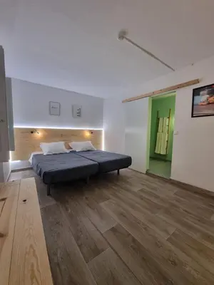 a bedroom with a bed in a room with wooden floors at Wonder Charm Guesthouse in Albufeira