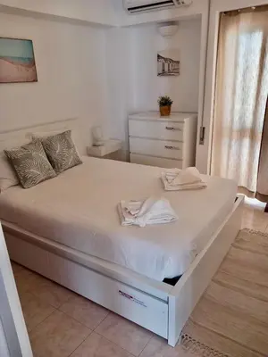 a white bed with two towels on it in a bedroom at Açoteias Secrets in Albufeira