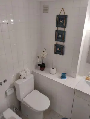 a white bathroom with a toilet and a sink at Açoteias Secrets in Albufeira