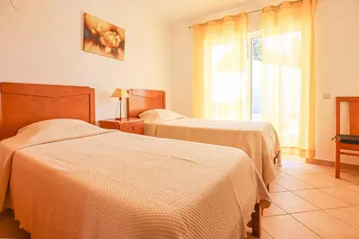 a hotel room with two beds and a window at Villa Tio Pedro - Swimming Pool - For families- BY BEDZY in Albufeira