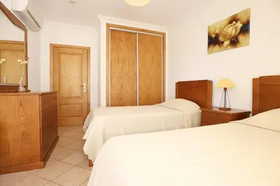 a hotel room with two beds and a dresser at Villa Tio Pedro - Swimming Pool - For families- BY BEDZY in Albufeira
