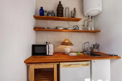 a kitchen with a counter with a microwave and a sink at Casa do Pateo in Guia