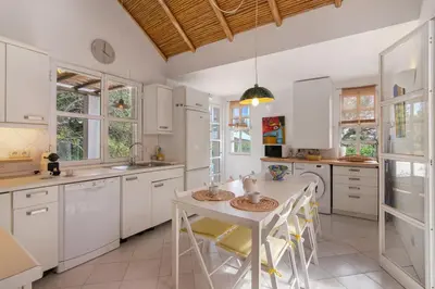 a kitchen with white cabinets and a table and chairs at Casa do Pateo in Guia