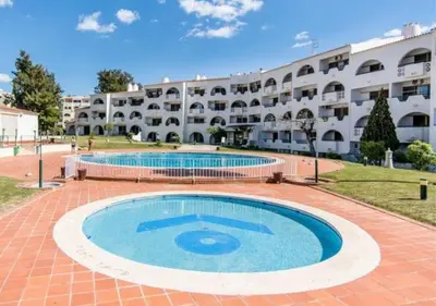 a large swimming pool in front of a building at Saro Apartment by HelloVacations in Albufeira