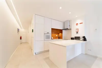 a kitchen with white cabinets and a white counter top at Saro Apartment by HelloVacations in Albufeira