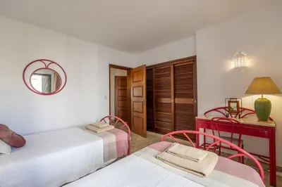 a bedroom with two beds and a mirror at Apartamento de 2 quartos Hibiscus 40A na Praia de Sao Rafael - Albufeira, Algarve in Albufeira