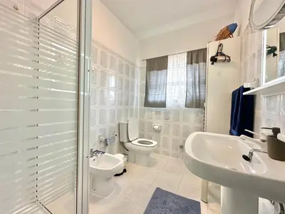 a white bathroom with a toilet and a sink at Casa Alfarroba - with heated indoor pool in Algoz