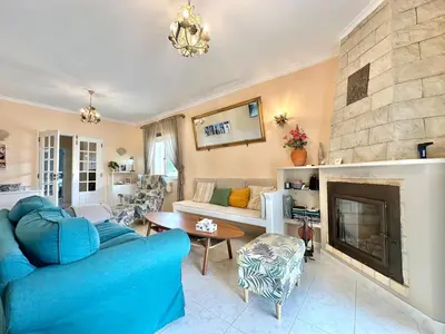 a living room with a blue couch and a fireplace at Casa Alfarroba - with heated indoor pool in Algoz