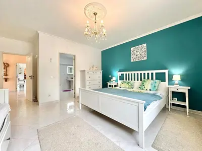 a bedroom with a white bed and a blue wall at Casa Alfarroba - with heated indoor pool in Algoz