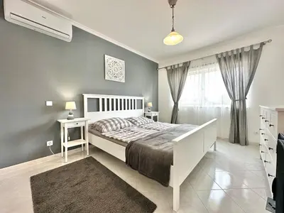 a bedroom with a white bed and a window at Casa Alfarroba - with heated indoor pool in Algoz